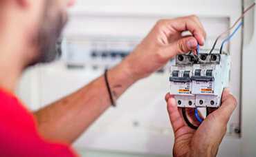 Electrician installing an RCD safety switch in a switchboard